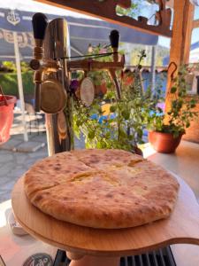 a pizza sitting on top of a cutting board at Daeli Hotel in Mestia