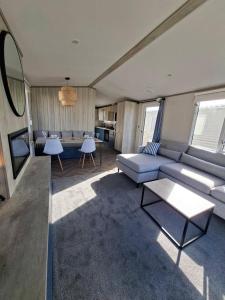 a living room with a couch and a table at Three Lochs Holiday Park, 139 Loch View with Lazy Spa Hot Tub, Platinum 3 bedroom Holiday Home for Hire in Balminnoch
