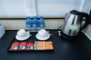 a table with a kettle and bottles of water and snacks at HoangAnh Hotel in Ha Long