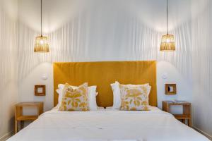 a bedroom with a large bed with a yellow headboard at CICAS VILLA in Albufeira