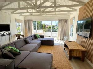 a living room with a couch and a table at Ocean Whisper Beach Villas in Jeffreys Bay