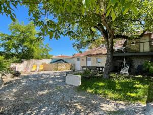 a house with a tree in the yard at Le Fenil in Floirac