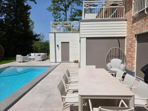 a patio with a table and chairs next to a swimming pool at Bed and Breakfast L'Orée Du Bois in Wavre