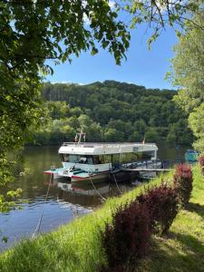 a boat is docked at a dock on a river at Am Obersee Hotel in Simmerath