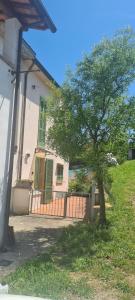 a tree in front of a house with a fence at Dimora Lo Zizzolo - Casa vacanze indipendente vicino Pontedera in Pontedera