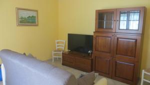 a living room with a couch and a tv at Dimora Lo Zizzolo - Casa vacanze indipendente vicino Pontedera in Pontedera