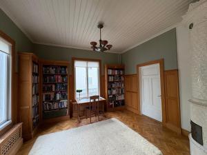 a room with bookshelves and a table and a window at Tornvillan in Mariehamn