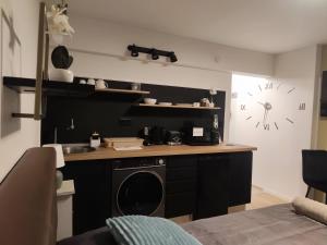 a kitchen with a black counter and a clock on the wall at B23 Apartman in Harkány
