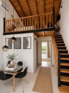 a living room with a staircase and a table and chairs at Euphoria Suites and Studios in Sidari