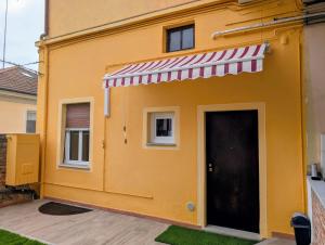a yellow house with a red and white awning at Monviso in Fossano