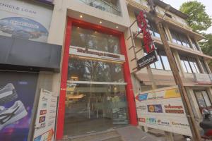 a store front with a red door on a street at Hotel Shrimmaya, Ujjain in Ujjain