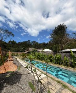 a swimming pool in a backyard with a fence at Domes and Dreams Lio Glamping in El Nido