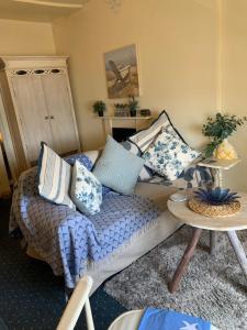 a living room with a couch and a table with pillows at The Suites At Ty Anne in Beaumaris
