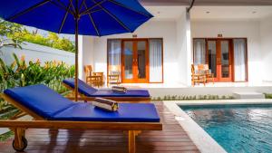 a pool with two lounge chairs and an umbrella at Royal Crown Villas in Ungasan