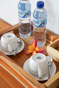 a tray with two cups and a bottle of water at Royal Crown Villas in Ungasan