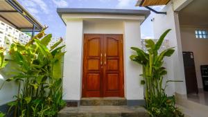 a wooden door on a white house with plants at Royal Crown Villas in Ungasan +47 photos