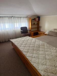 a bedroom with a large bed and a chair at La mansarda in Miranda
