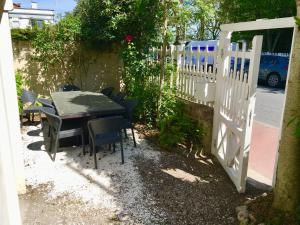 a table and chairs next to a white fence at Villa Myriam in Deauville
