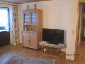 ein Wohnzimmer mit einem TV und einem Schrank in der Unterkunft Haus Schwärzler - Säntisblick in Sulzberg