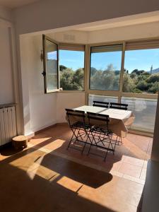 a room with a table and two chairs and windows at Appartement sagone in Coggia +7 photos