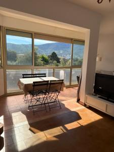a living room with a table and chairs and a large window at Appartement sagone in Coggia