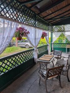 a screened porch with tables and chairs and flowers at Parkowe Ranczo in Poraj