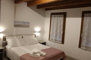 a bedroom with a bed with two white shoes on it at Villa Ander in Colà di Lazise