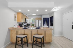 a kitchen with a large island with two bar stools at Stunning Sunset Scenes in Wesley Chapel +42 photos