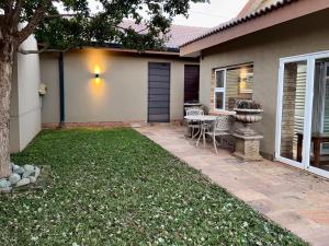 a patio with a table and chairs in front of a house at Be Our Guest Accommodation in Klerksdorp