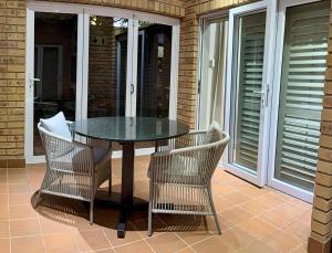 a glass table and two chairs on a patio at Be Our Guest Accommodation in Klerksdorp +4 photos