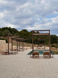 a group of benches sitting next to a pool at ORTO NOTO - Agri Resort in Noto