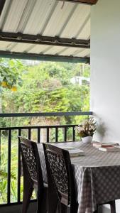 a table with chairs and a view of a balcony at Hang on in Anachal