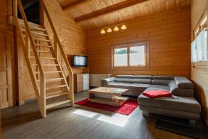 a living room with a couch and stairs in a cabin at Waldsiedlung - Haus 11 in Senftenberg