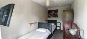 a room with two beds and a table with a lamp at Maindee Guest House in Barrow in Furness +35 photos