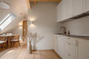 a kitchen with white cabinets and a dining table at Sava Nida in Neringa