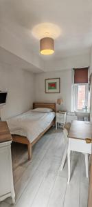 a bedroom with a bed and a table at Maindee Guest House in Barrow in Furness