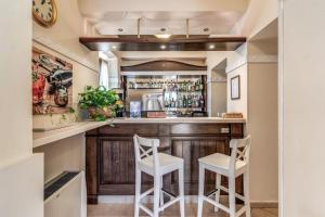 a bar in a home with two white stools at Hotel Villa Ambrosina in Impruneta