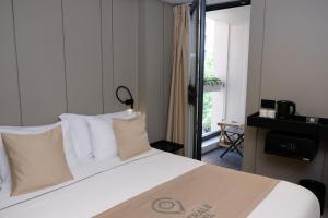 a bedroom with a bed with white sheets and a window at Centrale Hotel in Tirana