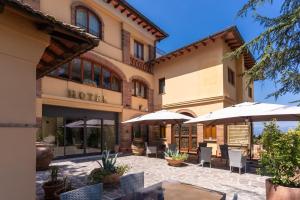 a hotel with a patio with chairs and umbrellas at Hotel Villa Ambrosina in Impruneta
