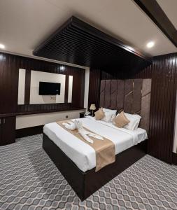 a bedroom with a large bed and a flat screen tv at Sylhet Comfort Stay Hotel in Sylhet