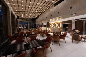 a restaurant with tables and chairs in a room at Mora Hotel in Jeddah