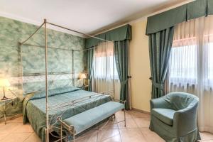 a bedroom with a canopy bed and a chair at Hotel Villa Ambrosina in Impruneta +50 photos