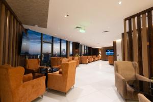 a waiting room with chairs and tables and windows at Mora Hotel in Jeddah
