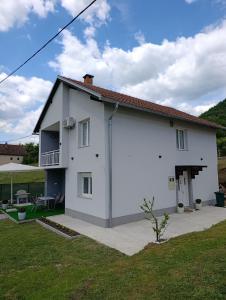 a white house with a patio and a yard at Vikend kuća Konjic in Konjic