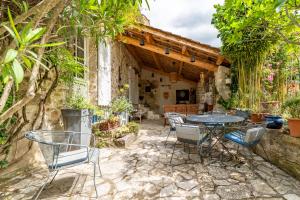 an outdoor patio with a table and chairs at Mas Escombelle in Barjac