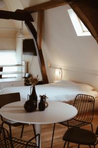 a room with two beds and a table and chairs at B&B De Mout in Diest