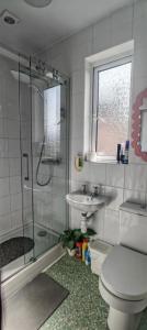 a bathroom with a shower and a toilet and a sink at Maindee Guest House in Barrow in Furness