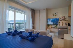 a large blue bed in a room with a kitchen at The Terraza Condotel in Nathon Bay
