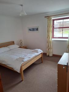 a bedroom with a bed and a window at Glen Lyon in Inverurie