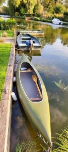 a green canoe sitting in the water at a dock at Maison La Béa-titude in Serques +11 photos